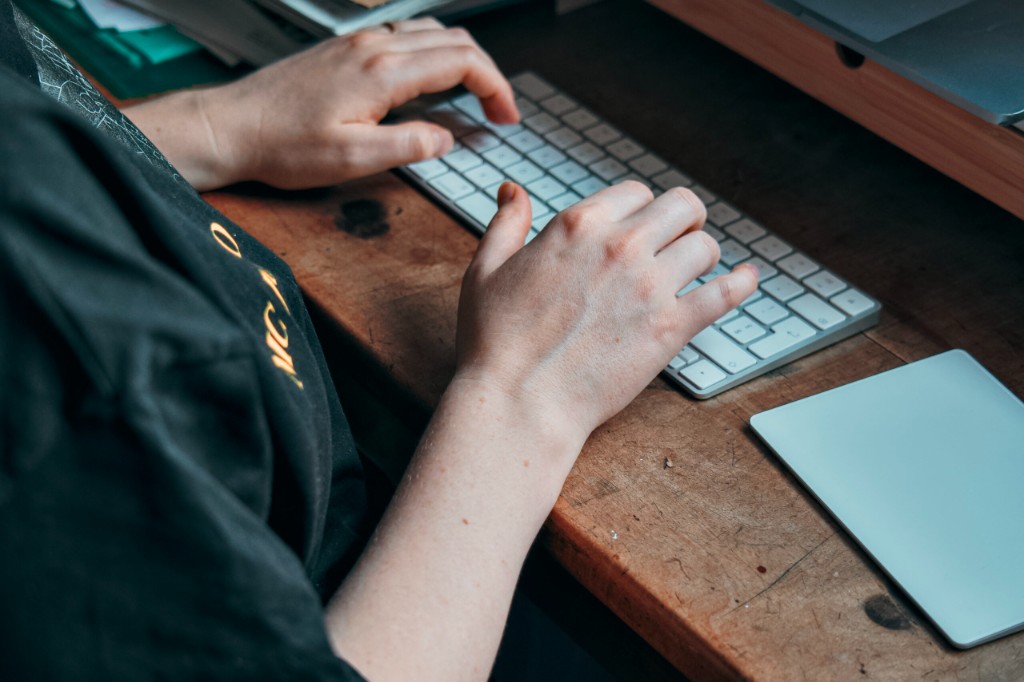 Mains au clavier dans l’atelier L’Atelier Chenaux — création impression 3D, vidéo et stickers
